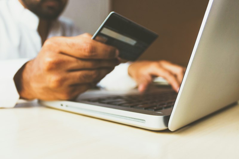 Person entering financial details on laptop
